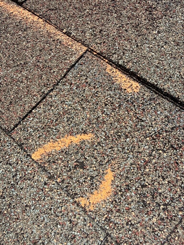 Hail hit marked on a shingle during a storm damage inspection in Peachtree City, GA